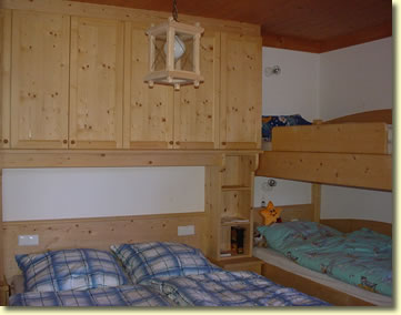Schlafzimmer mit Einbauschr&auml;nken, Doppelbett und Stockbett